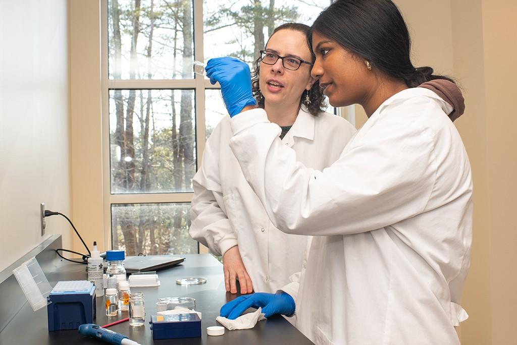 Two students looking at a microscope slide